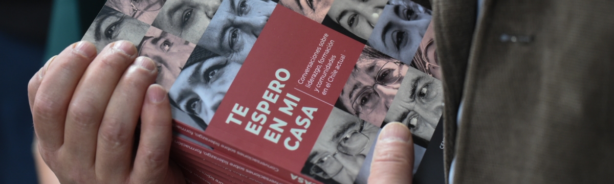 Las manos de una persona sostienen un montón de copias del libro "Te espero en mi casa"