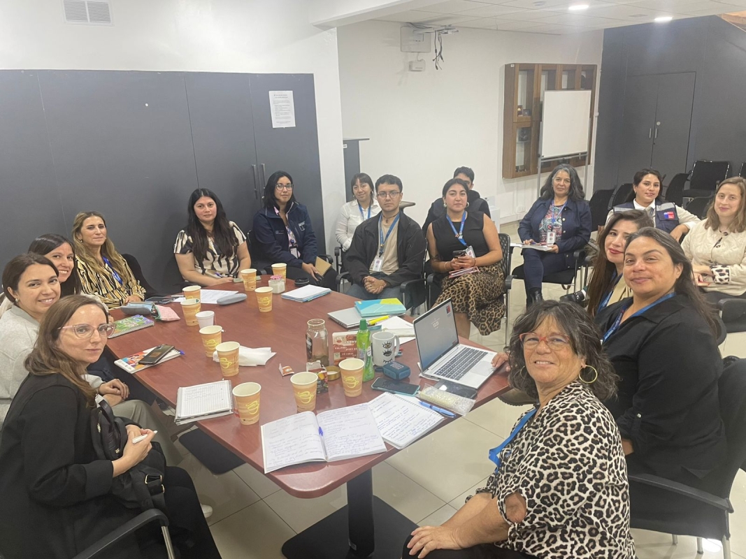 Muchas personas en reunión alrededor de una mesa