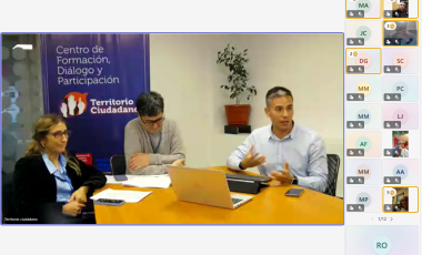 Tres personas sentadas alrededor de una mesa dando clase online