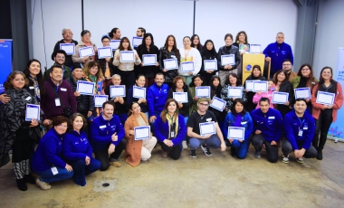 Grupo numeroso de personas sosteniendo un certificado