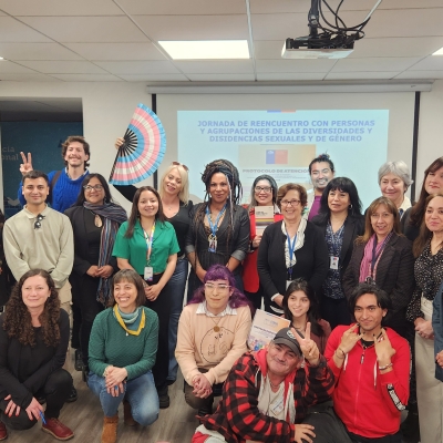 Grupo de personas de pie y en cuclillas en un salón mirando a cámara