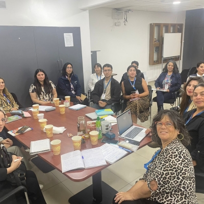 Muchas personas en reunión alrededor de una mesa