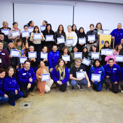 Grupo numeroso de personas sosteniendo un certificado
