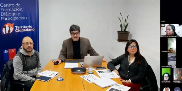 Tres personas sentada alrededor de una mesa dando clase online